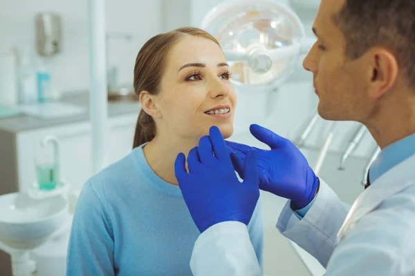 Весела жінка дивиться на свого стоматолога — стокове фото