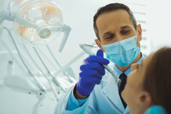 Dentista atento tratando seu paciente — Fotografia de Stock