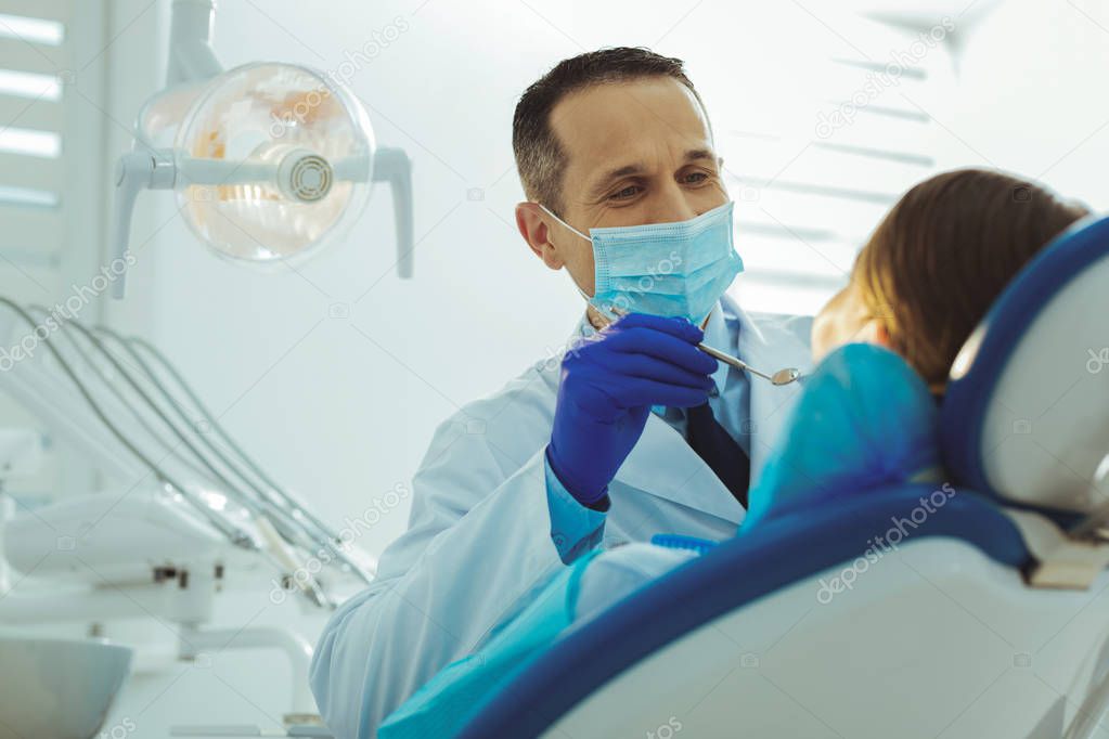 Attractive dentist treating his patient