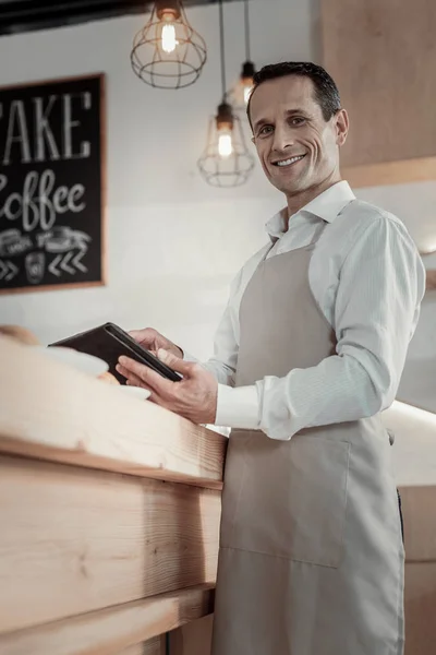 Vrolijke mannelijke persoon zijn gadget gebruiken — Stockfoto