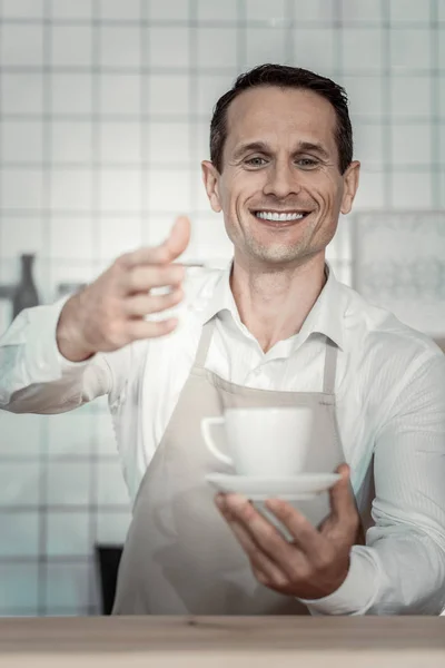 Pleased barista holding fragrant drink — Stock Photo, Image