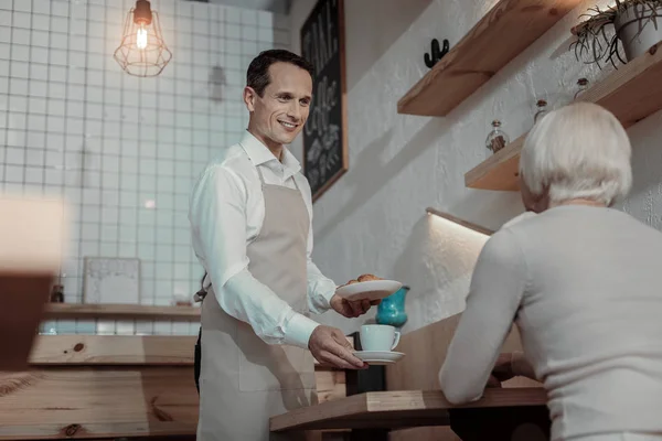 Atractivo trabajador trayendo café a su cliente — Foto de Stock