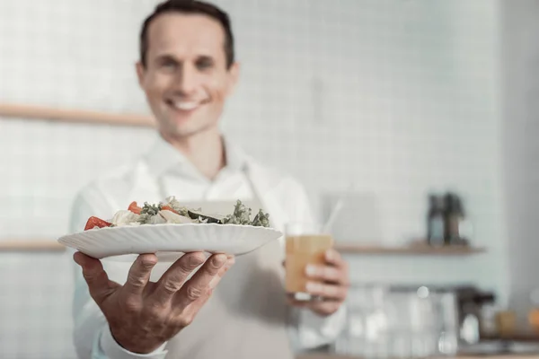 Foto enfocada en la mano masculina que demuestra ensalada —  Fotos de Stock