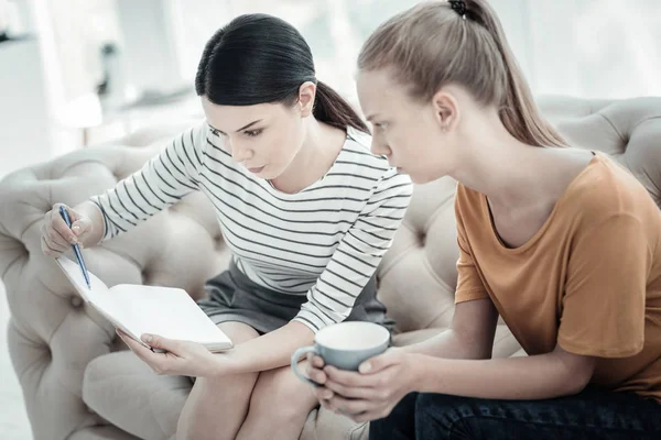 Concentrated female psychologist drawing scheme — Stock Photo, Image