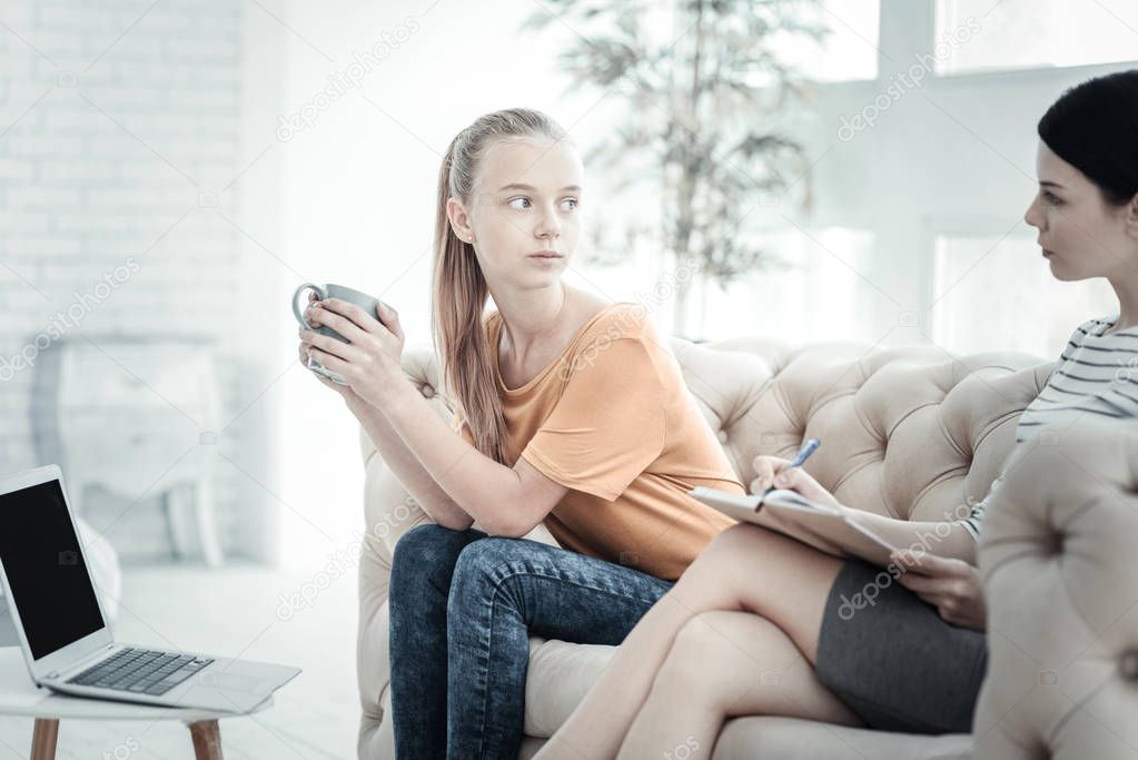 Female psychologist discussing problems with attentive teenager