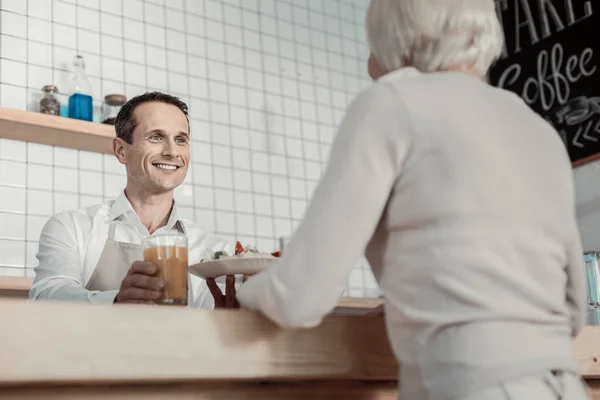 Pleased waiter looking at his visitor — Stock Photo, Image