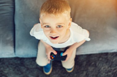 Bir oyun konsolu ile oturma oynak çocuk
