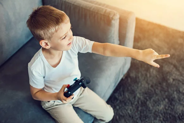 Criança atenta com consola de jogos brilhantes em suas mãos — Fotografia de Stock