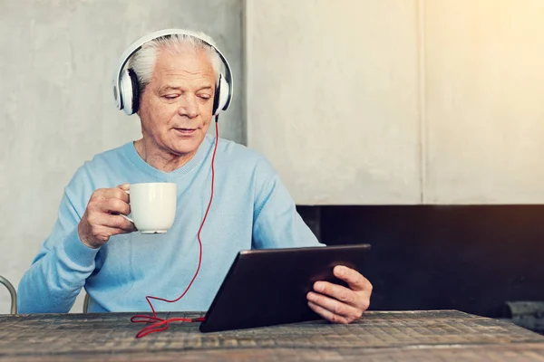 Jubilado relajado viendo videos y tomando té —  Fotos de Stock