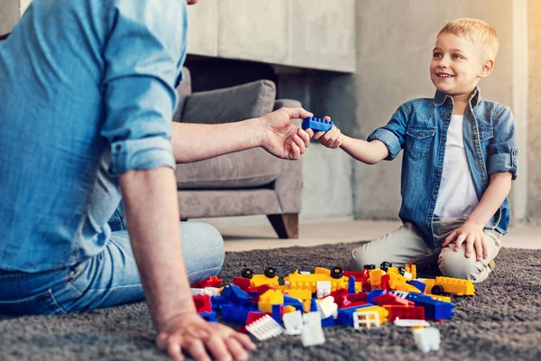 Felice bambino dando un mattone blu al suo parente — Foto Stock