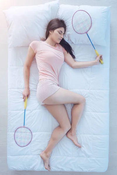 Mulher cansada jogando badminton enquanto dormia — Fotografia de Stock