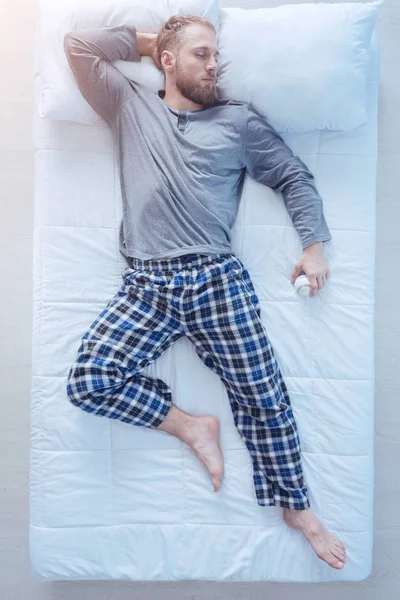 Jovem dormindo na cama com beisebol na mão — Fotografia de Stock