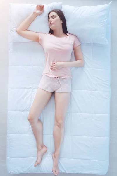 Уставшая девушка спит крепко в постели — стоковое фото