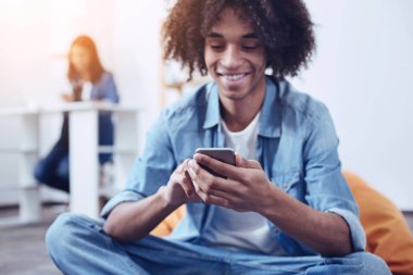 Yakışıklı melez onun smartphone kullanarak