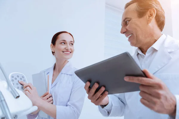 Mogen läkare håller hans gadget i båda händer — Stockfoto