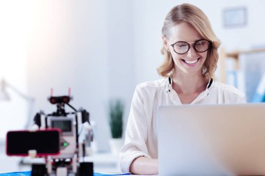 Dizüstü bilgisayar ekranına bakarak neşeli çekici kadın