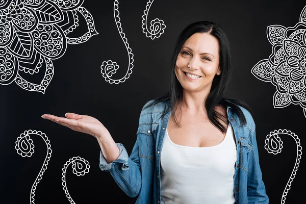 Artista alegre sonriendo y mostrando su nueva pintura — Foto de Stock