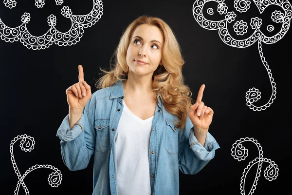 Young woman wearing casual clothes and pointing her fingers up — Stock Photo, Image