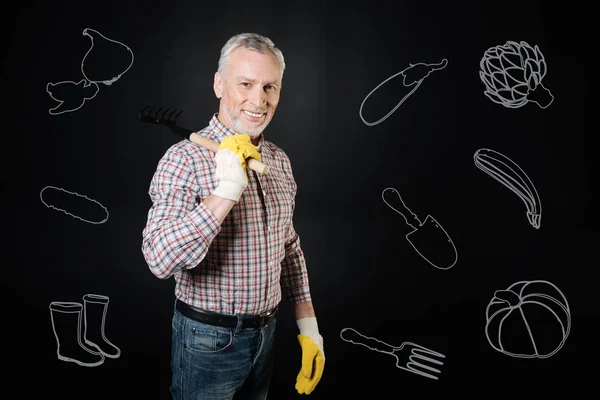 Emotional handsome man smiling and working in the garden — Stock Photo, Image