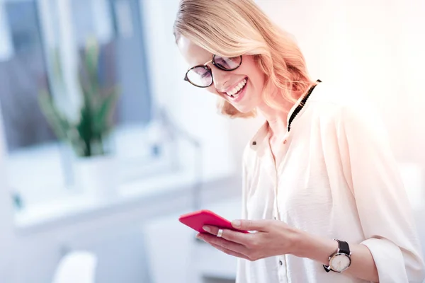 Mujer atractiva feliz sosteniendo su teléfono inteligente — Foto de Stock