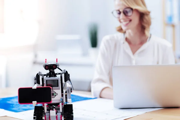 Bonito robot inteligente sosteniendo un teléfono inteligente —  Fotos de Stock