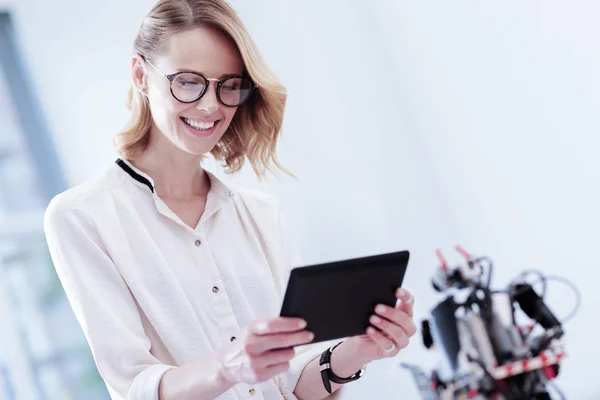 Mulher sorridente positivo olhando para a tela do tablet — Fotografia de Stock