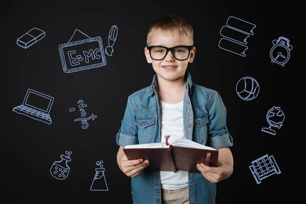 Calm boy holding a book and standing alone — Stock Image Calm boy holding a book and standing alone Stock Photo