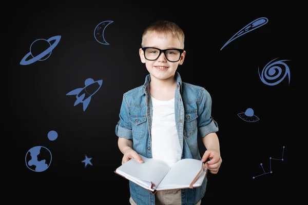 Calm child holding a book and dreaming about space — Stock Image Calm child holding a book and dreaming about space Stock Picture
