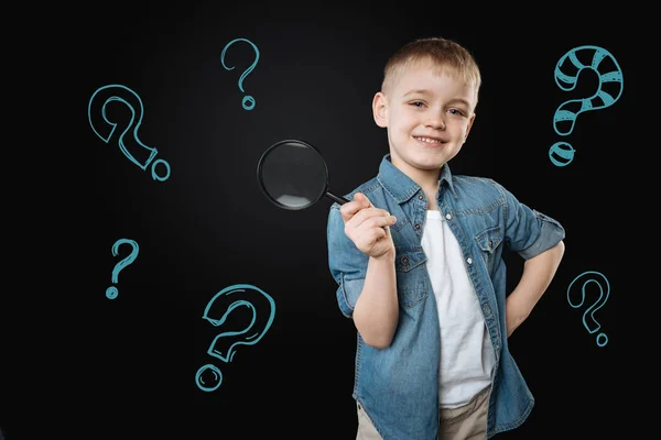 Cute boy holding a magnifying glass and looking glad — Stock Image Cute boy holding a magnifying glass and looking glad Stock Image