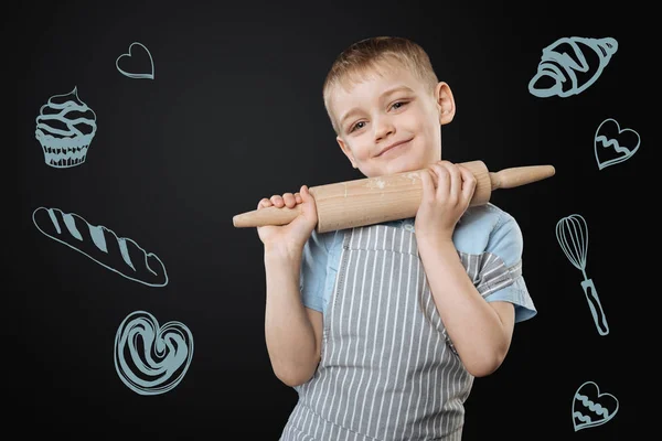 Pretty child standing with a rolling pin and looking cute — Stock Image Pretty child standing with a rolling pin and looking cute Stock Photo