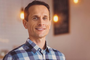 Ekose desenli bir gömlek içinde büyüleyici genç bir adam portresi