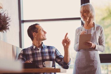 Hoş adam kruvasan ın kafede garson üzerinden sipariş