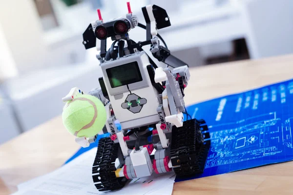 Ένα έξυπνο ρομπότ καινοτόμες κρατώντας μια μπάλα του τένις σε κοντινό πλάνο — Φωτογραφία Αρχείου