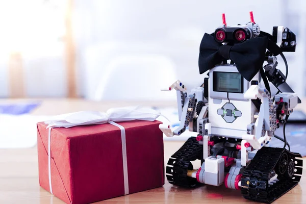 Милий чоловічий робот стоїть біля подарункової коробки — стокове фото