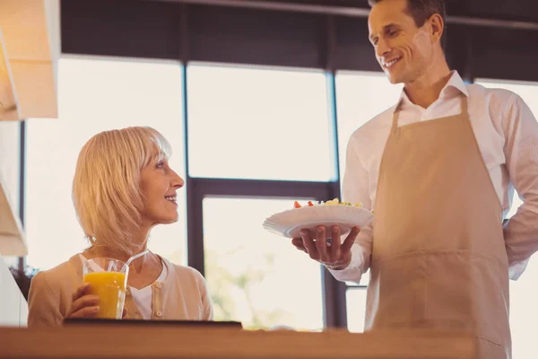 Bonito homem segurando uma ordem de seu cliente sênior — Fotografia de Stock