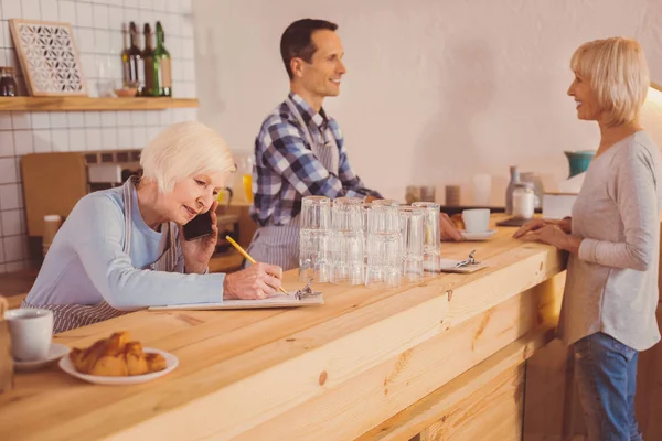 Propietario agradable cafetería colocación de pedidos a los proveedores y tomar notas — Foto de Stock