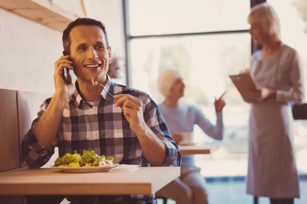 Öğle yemeği ve telefonda konuşurken büyüleyici işadamı — Stok fotoğraf