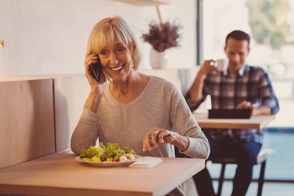 Vidám nő eszik saláta és csevegnek a telefon — Stock Fotó