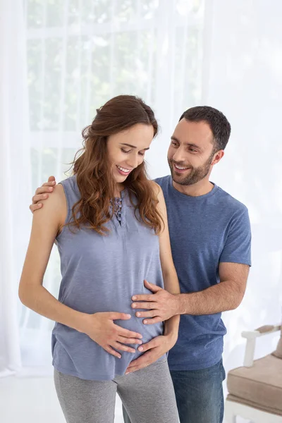 Homem alegre se preocupando com a mulher grávida — Fotografia de Stock