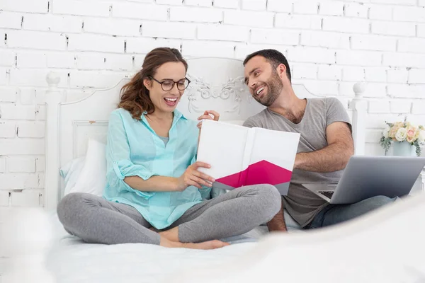 Mujer embarazada exuberante y hombre riéndose de libro — Foto de Stock