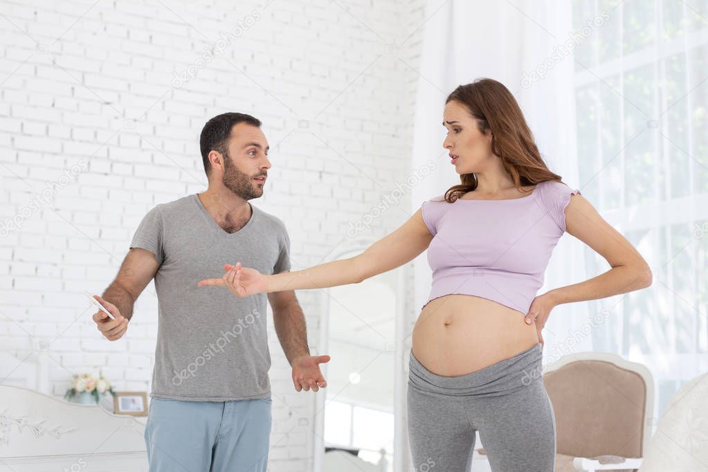 Grumpy man and pregnant woman fighting