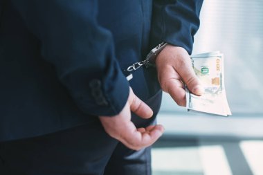 Ciddi bir suç. Kelepçe takıyor ve para tutan iyi bilinen para fikirli politikacı