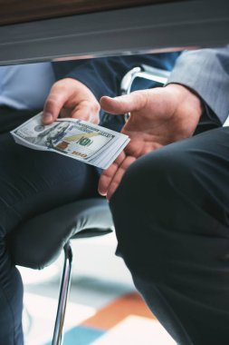 Kanuna karşı. Başka bir işadamı yanında oturan ve giving onu masanın altında rüşvet ilkesiz zengin iş adamı