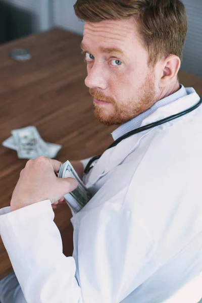 Concentrated wicked doctor taking money