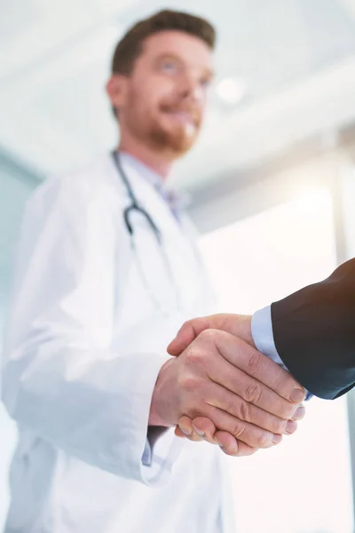 Inspirerad läkare skakar hand med en affärsman — Stockfoto
