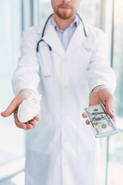 Серьезный врач забирает деньги у своих пациентов — стоковое фото