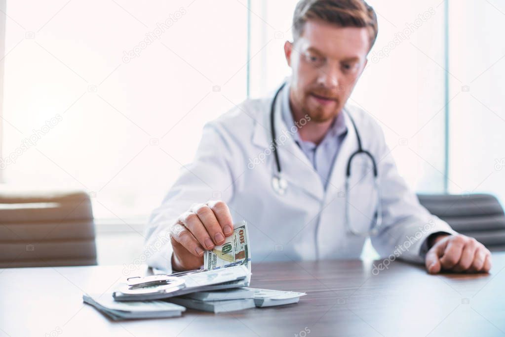 Skilled doctor taking bribes in his office