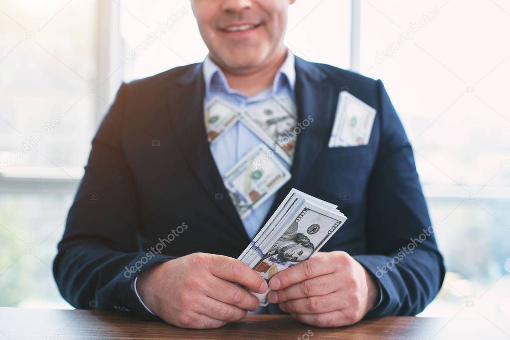 Smiling successful businessman taking bribes