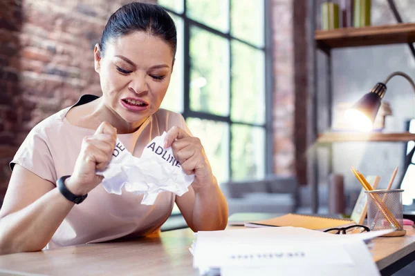 Boos vrouwelijke werknemer scheuren van papier — Stockfoto