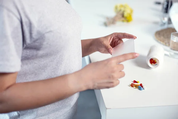 Jeunes mains féminines comptant les pilules — Photo